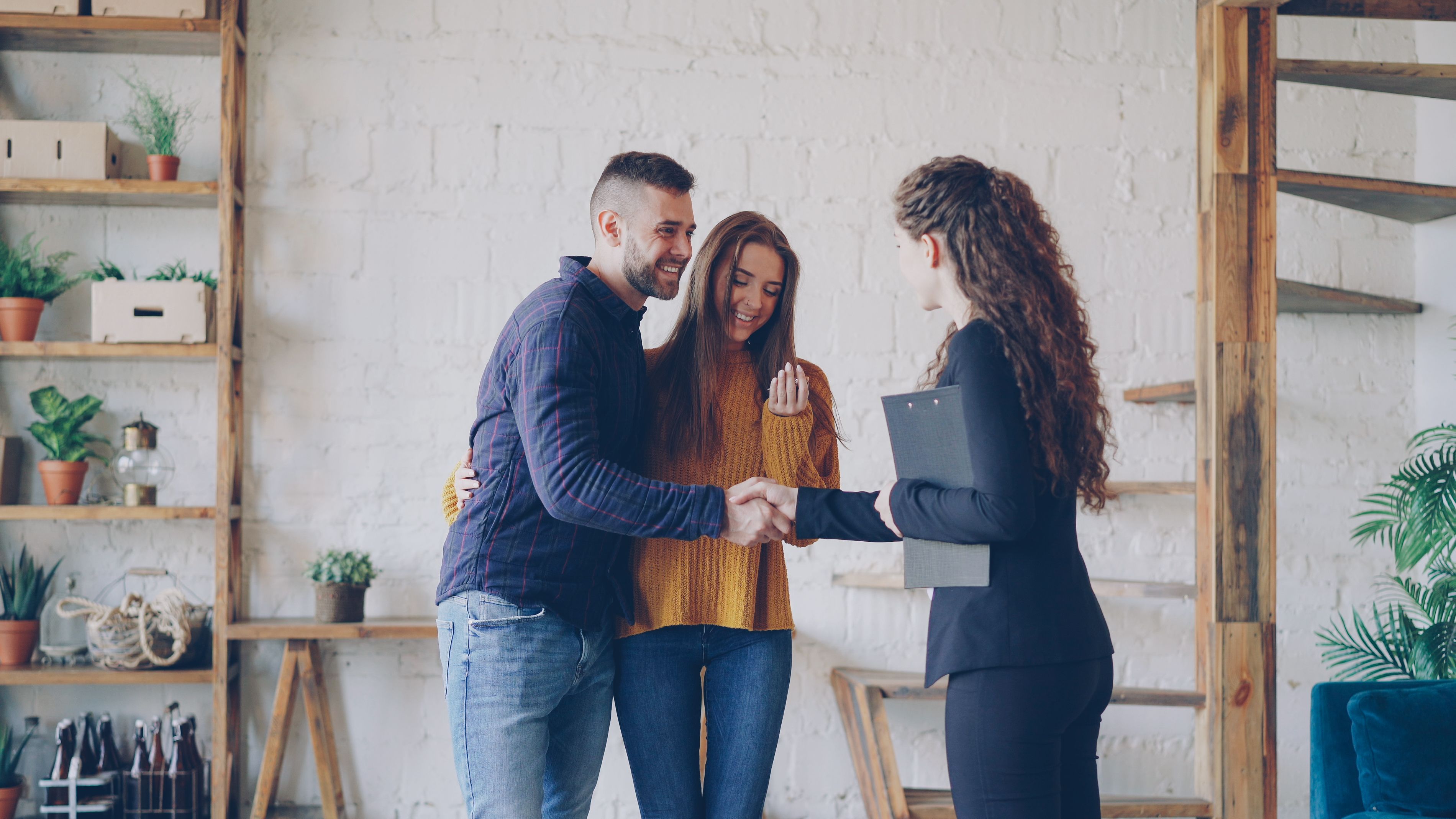 Happy homeowners shaking hands with a service professional